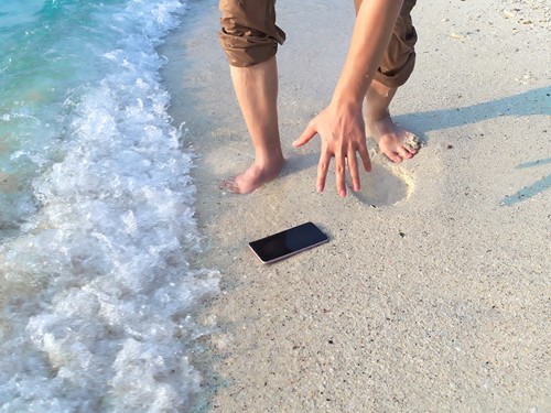 A smartphone dropped on a beach