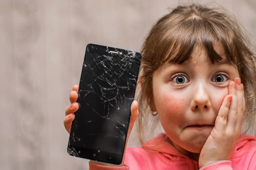 Child holding broken smartphone