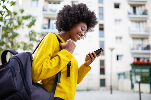 A person walking whilst holding a smartphone