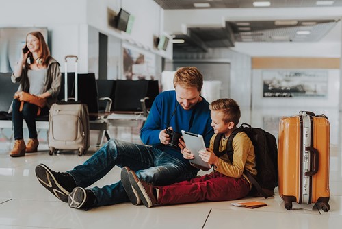 Parents with a child using gadgets at an airport